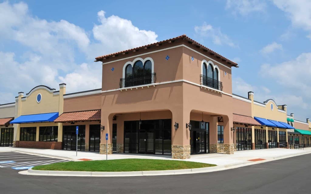 Freshly resurfaced retail plaza parking lot with crisp striping at Mediterranean-style shopping center in New Brunswick, NJ
